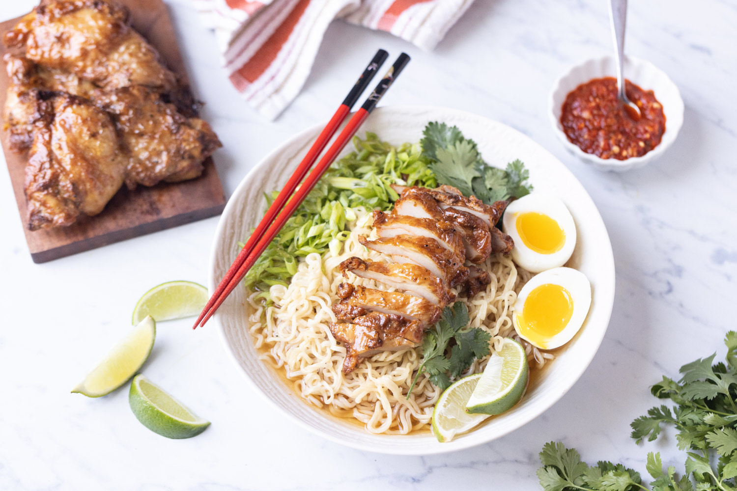 A bowl of ramen with noodles, chicken, eggs, and greens